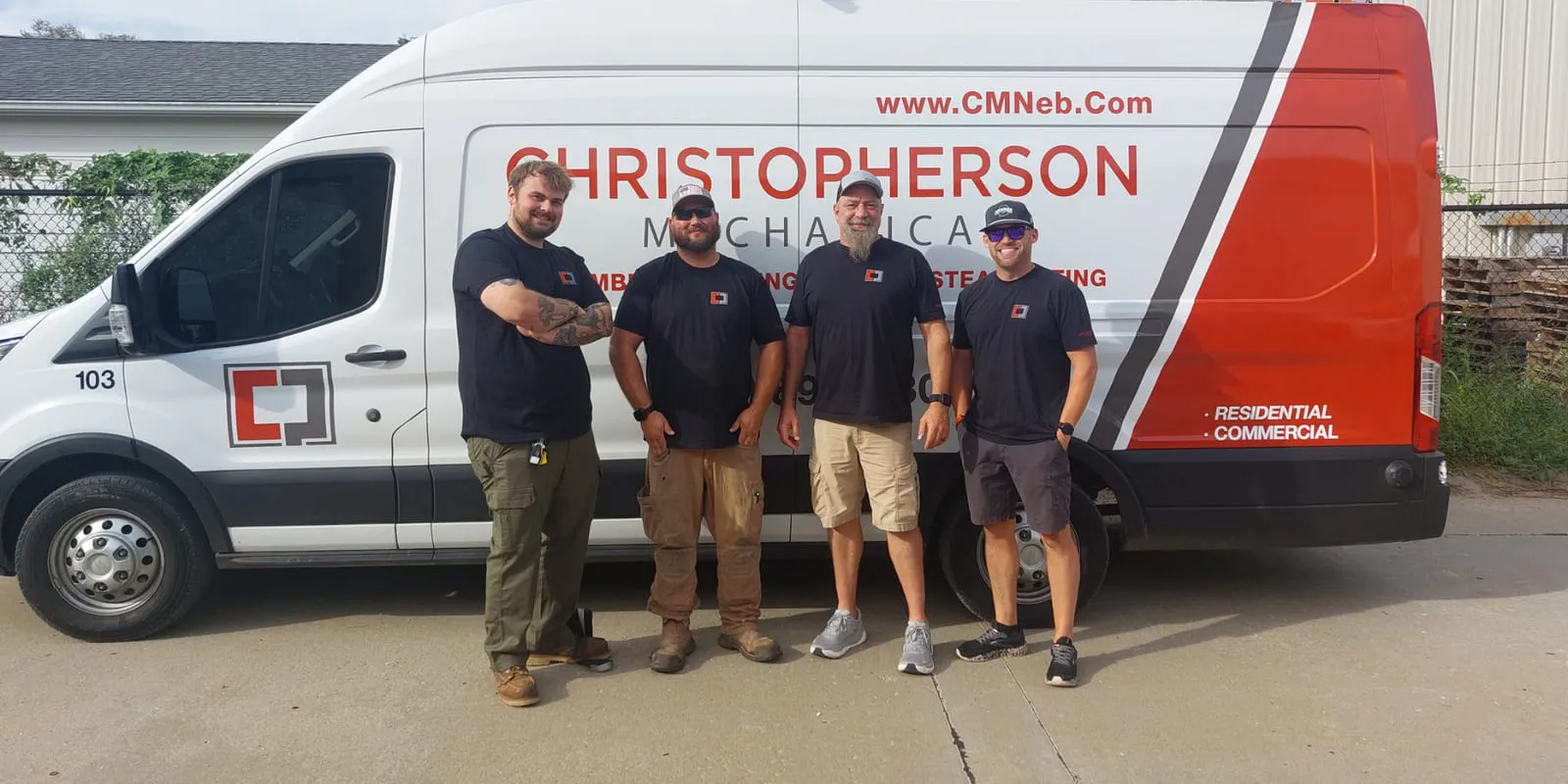 Four Christopherson Mechanical technicians standing in front of the company service van, lettered with the Christopherson Mechanical logo and plumbing, heating, air, and steamfitting services.